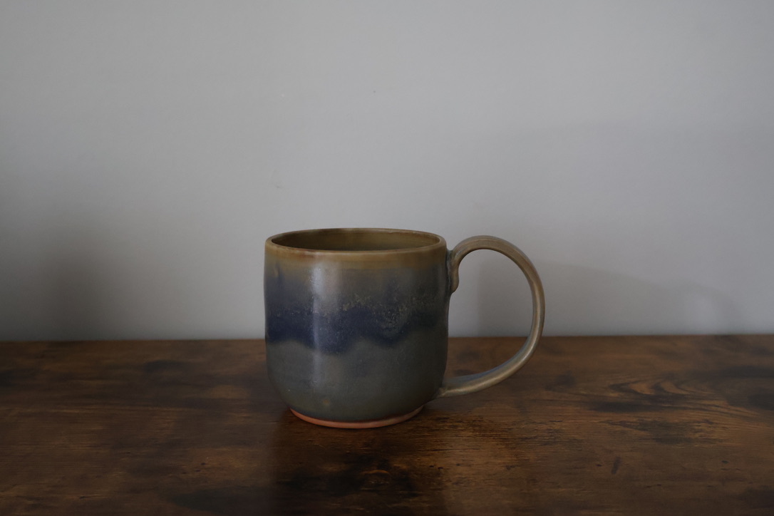 Hand-thrown mug with blue and sand drip glaze