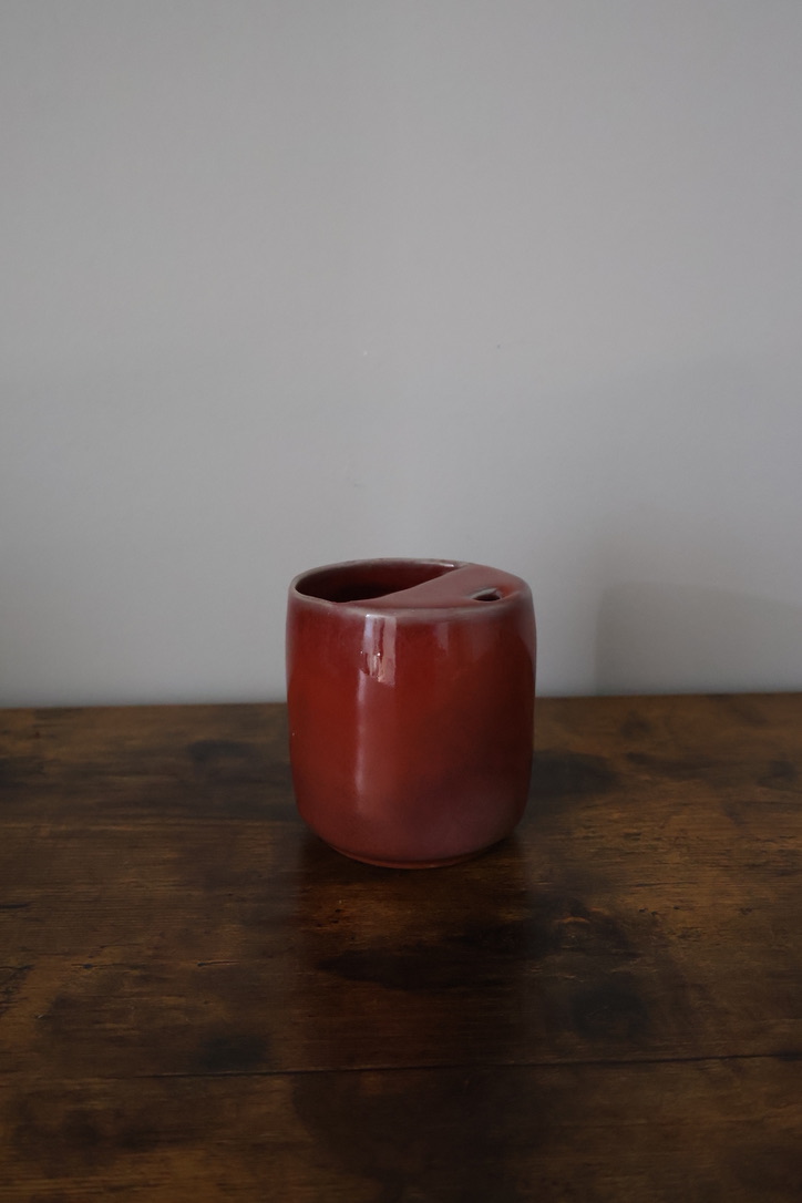 Deep red glazed ceramic cup with angled rim